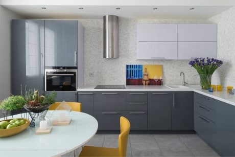 Modern kitchen with sleek gray cabinetry, stainless steel appliances, and bright yellow accents.