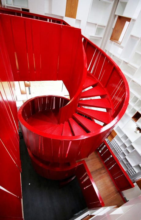 Striking red spiral staircase with sleek, modern design and architectural elements.