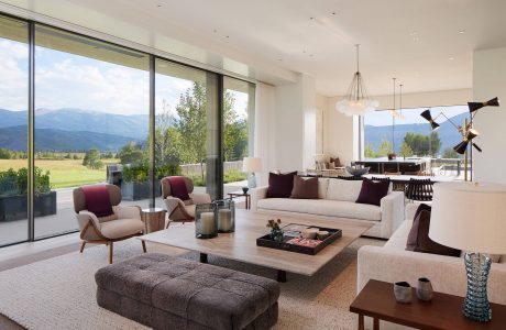 Spacious living area with large windows overlooking scenic mountain landscape.