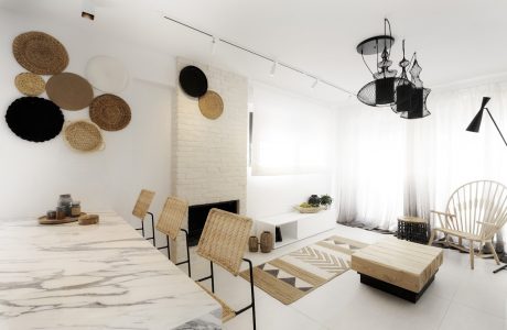 Minimalist living room with natural materials, geometric patterns, and modern lighting.