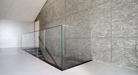 A minimalist glass and concrete staircase with sleek, modern design elements.