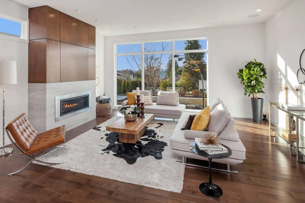 Spacious living room with contemporary fireplace, built-in storage, and large windows.