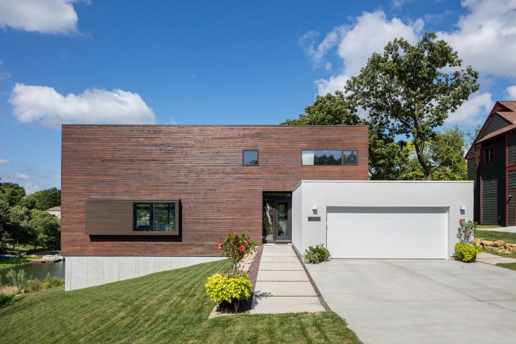 Contemporary wood-paneled home with clean-lined design, large windows, and well-landscaped yard.