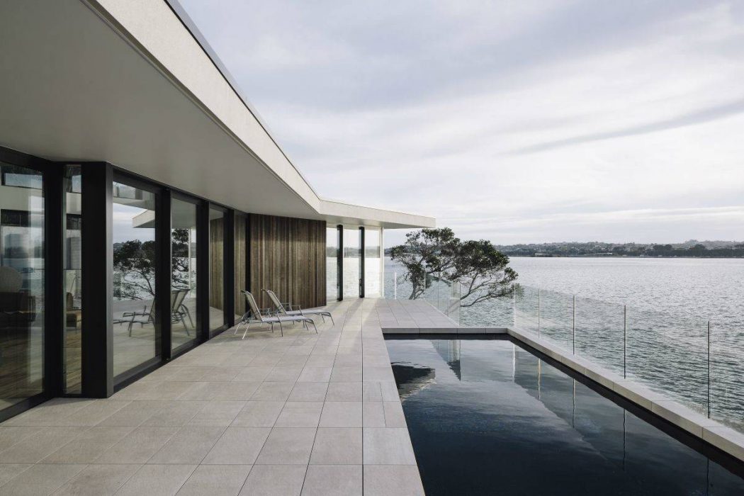 A modern waterfront home with sleek architectural features and an infinity pool.