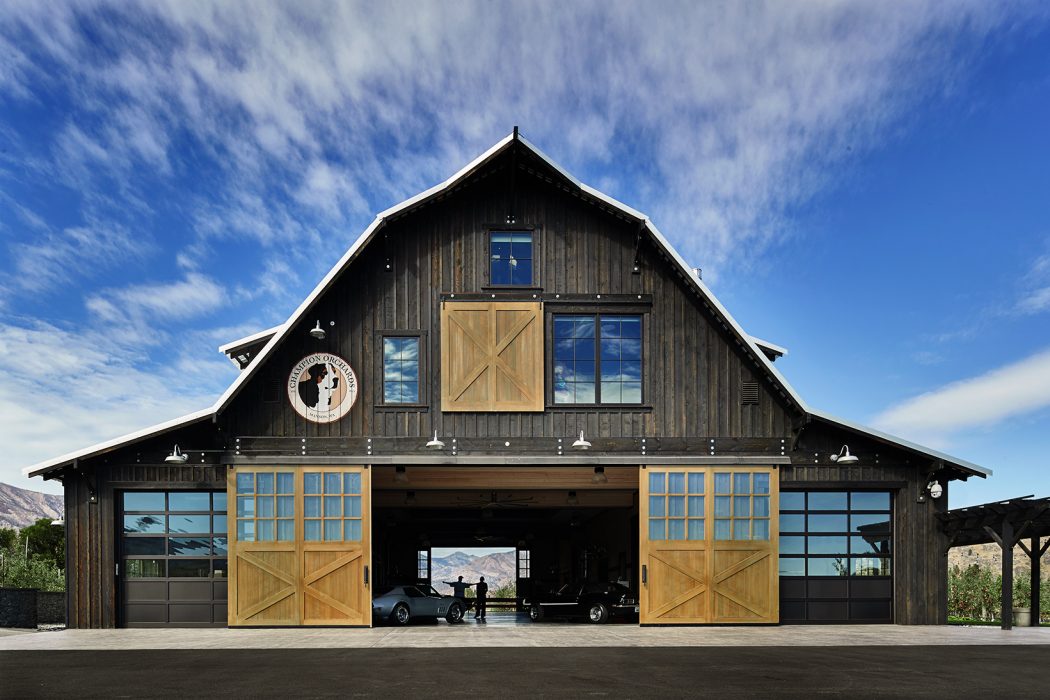 Rustic wood-paneled barn with large double doors, expansive windows, and a peaked roof.