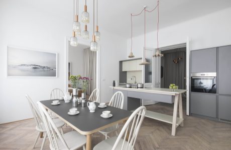 Modern, bright dining space with pendant lighting, wooden table, and minimalist decor.