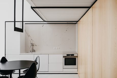 Minimalist kitchen with sleek cabinets, marble backsplash, and modern pendant lights.