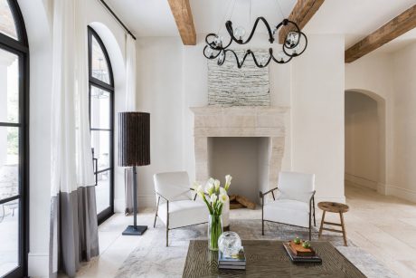 Bright, rustic-chic room with wooden beams, stone fireplace, and modern furnishings.