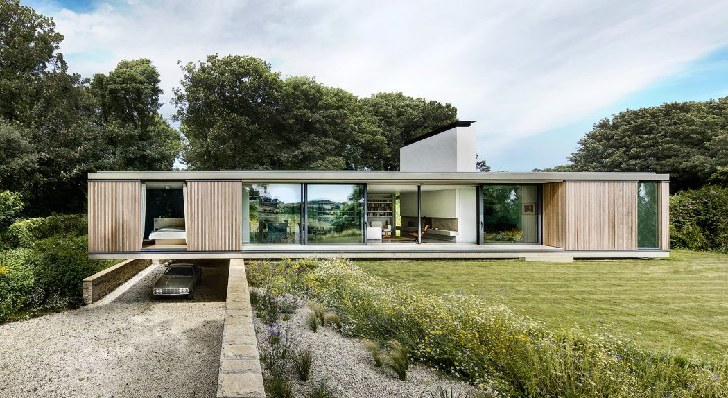 A modern, low-profile, single-story residence with large glass windows and a wooden exterior.