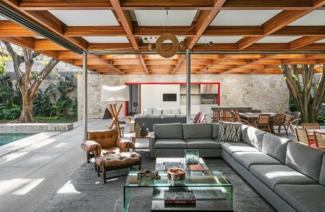 Luxurious open-plan living space with wooden beams, stone walls, and modern furnishings.