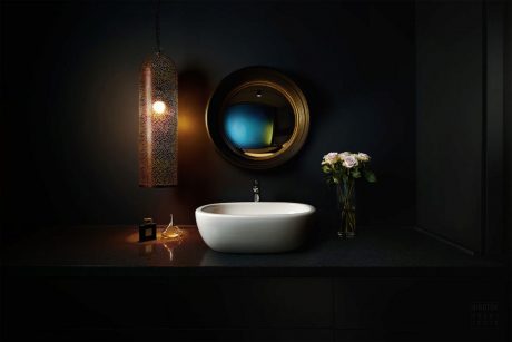 Cozy bathroom decor with modern basin, ornate mirror, and soft lighting.