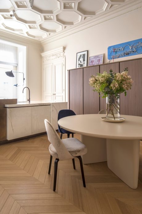 Ornate, paneled ceiling, marble countertop, floral arrangement, minimalist dining area.