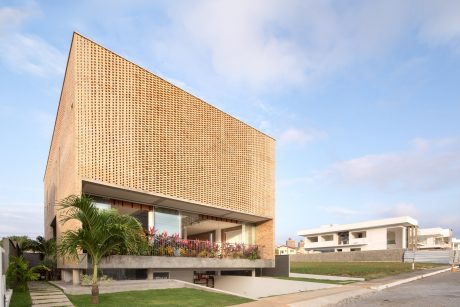 A modern building with a striking angular facade clad in a perforated golden material.