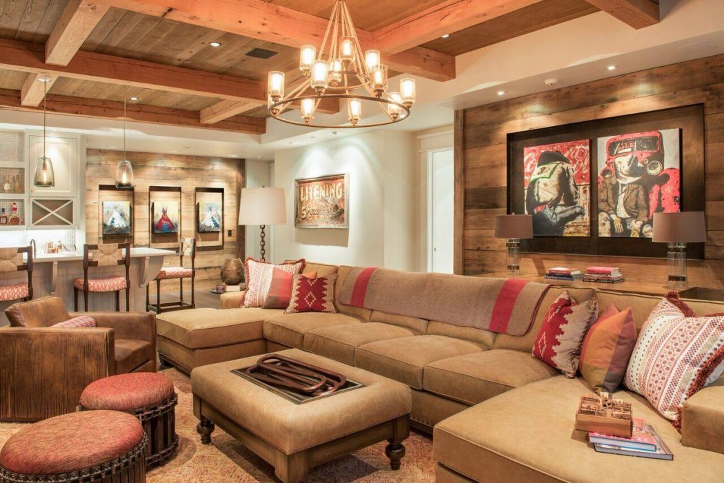 Rustic, cozy living room with wooden beams, chandelier, and textured wall panels.