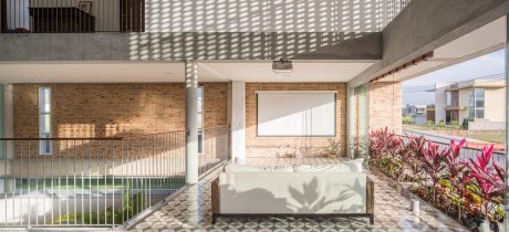 Patio with brick walls, potted plants, and a cozy seating area under a covered roof.