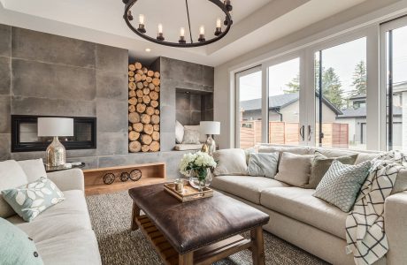 Cozy living room with stone fireplace, wooden decor, and modern chandelier.