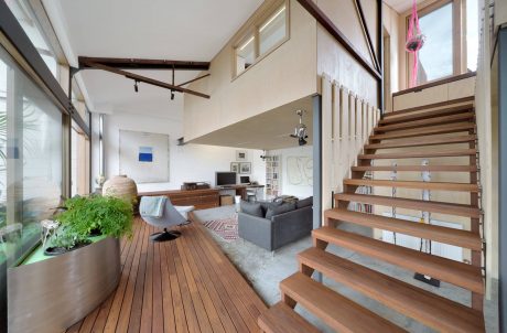 Spacious open-concept interior with exposed beams, wood floors, and modern furniture.