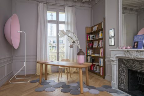 A charming interior with a stylish fireplace, bookshelves, and a wooden table amid elegant decor.