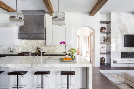 Spacious kitchen with marble countertops, wooden beams, and hanging pendant lights.