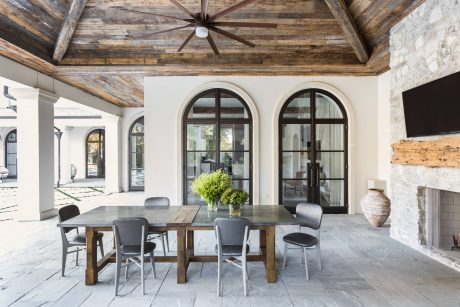 Rustic wood-beamed ceiling, arched windows, and stone walls create a warm, inviting interior.