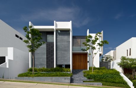 Modern, minimalist architecture with clean lines, natural elements, and surrounding greenery.