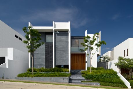 Modern, minimalist architecture with clean lines, natural elements, and surrounding greenery.