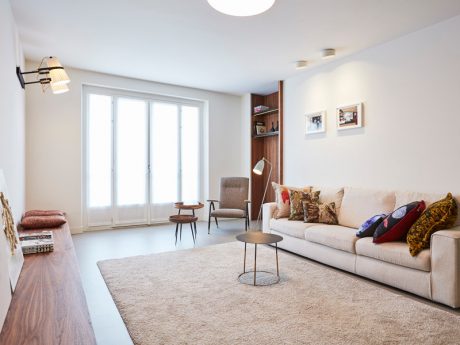 Bright, airy living room with modern furnishings, large windows, and a cozy ambiance.