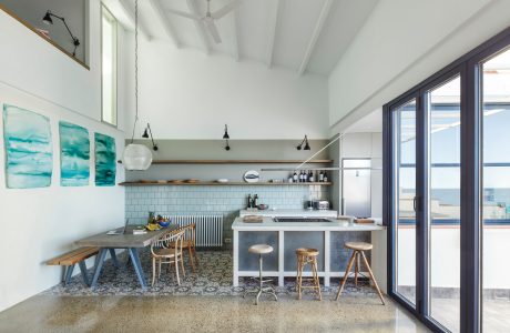 A modern, open-concept kitchen with a neutral palette, sleek fixtures, and a cozy dining nook.