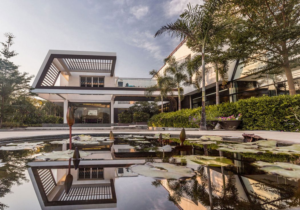 Stunning modern architecture with reflecting pool, tropical foliage, and elegant design features.