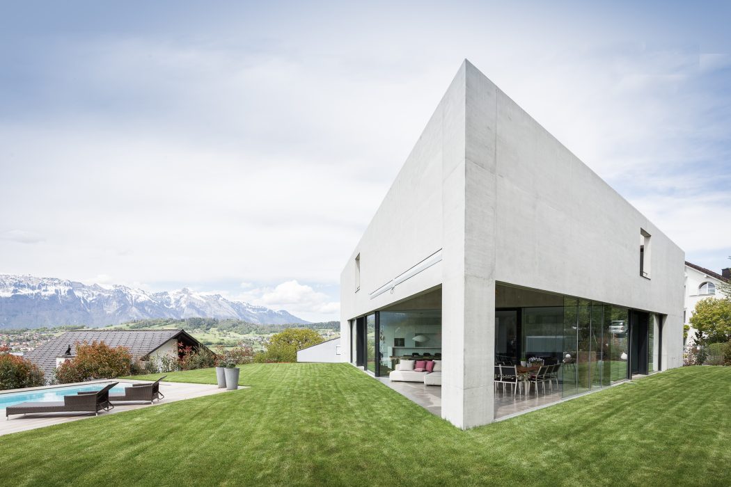 Sleek, minimalist architecture with expansive glass walls framing snow-capped mountain views.