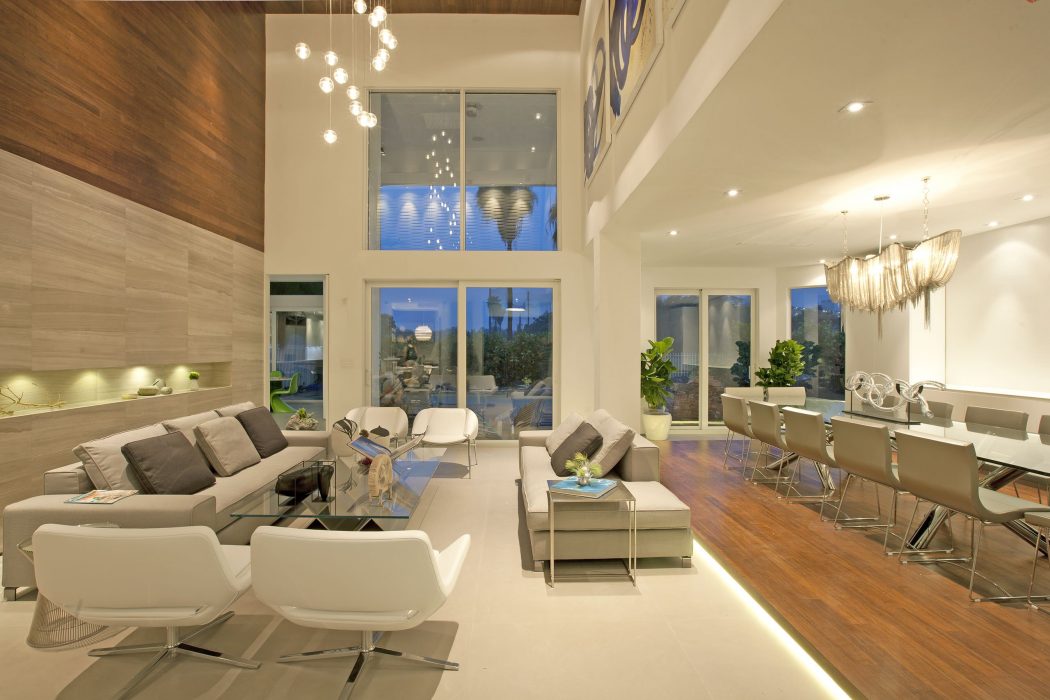 Luxurious open-concept living room with modern furnishings and floor-to-ceiling windows.