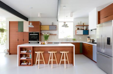 Bright, modern kitchen with wood cabinetry, white island, and colorful accents.