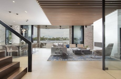 Spacious modern living room with wooden ceiling beams and floor-to-ceiling windows.