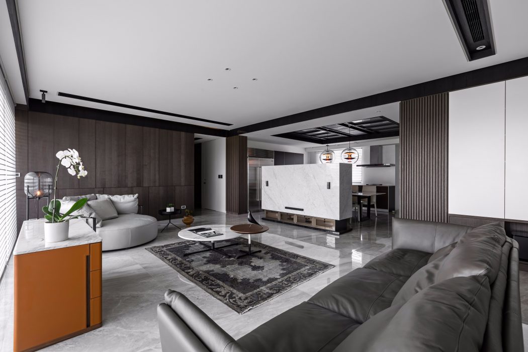 Spacious modern living room with sleek furniture, marble flooring, and pendant lighting.