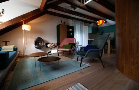 Cozy rustic living room with plush seating, exposed wooden beams, and colorful accents.