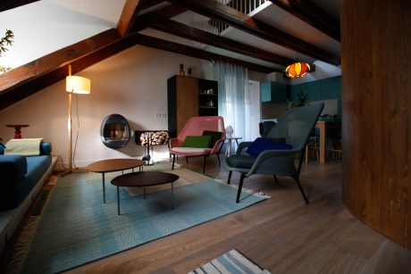 Cozy rustic living room with plush seating, exposed wooden beams, and colorful accents.