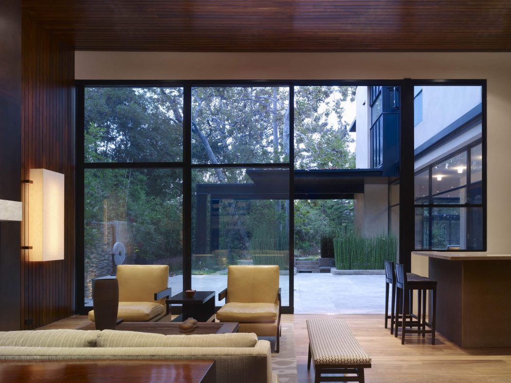 Elegant modern living space with floor-to-ceiling windows overlooking a lush garden.