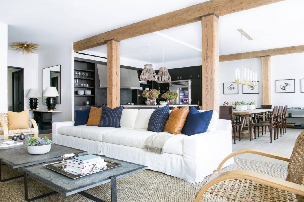 Spacious open-plan living area with exposed beams, white sofa, and rustic accents.