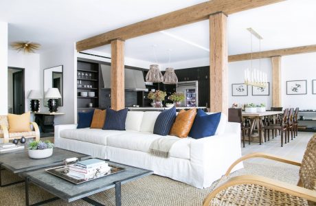 Spacious open-plan living area with exposed beams, white sofa, and rustic accents.