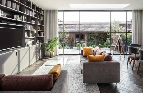 Spacious living room with large windows, built-in shelves, and modern furnishings.