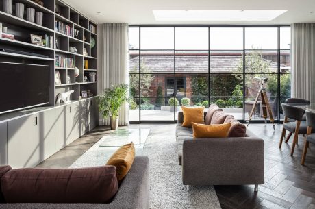 Spacious living room with large windows, built-in shelves, and modern furnishings.