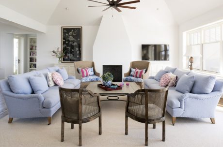 Bright, airy living space with plush seating, wood furniture, and striking artwork.