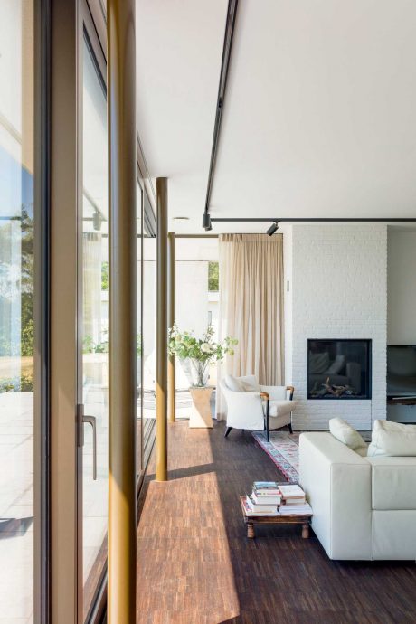 Bright, airy living room with floor-to-ceiling windows, wood floors, and a fireplace.