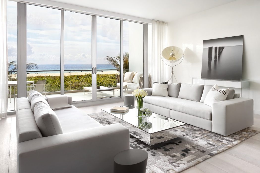 Spacious living room with contemporary decor, large windows providing panoramic ocean view.