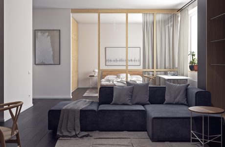 Minimalist bedroom with gray walls, dark sofa, and wooden accents creating a cozy ambiance.