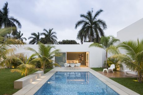 Sleek, modern outdoor living space with pool, palms, and inviting open-concept interior.