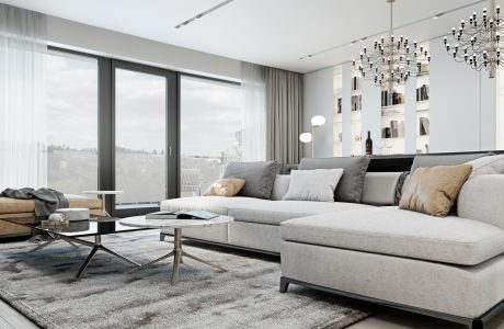 A modern, minimalist living room with large windows, a plush gray sectional, and intricate chandeliers.