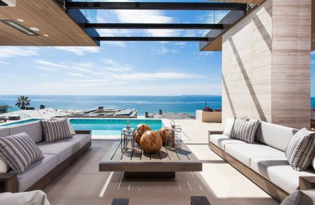 Stunning modern beachfront terrace with sleek furniture, pool, and panoramic ocean views.