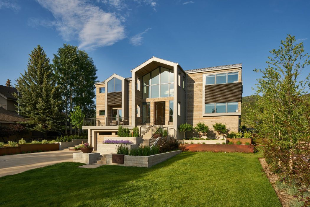 A contemporary, multi-level home with unique architectural elements, expansive windows, and lush landscaping.