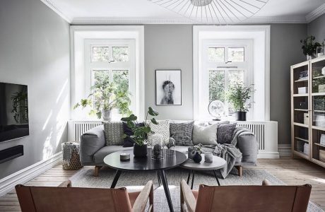 Cozy living room with large windows, gray walls, and modern furniture.